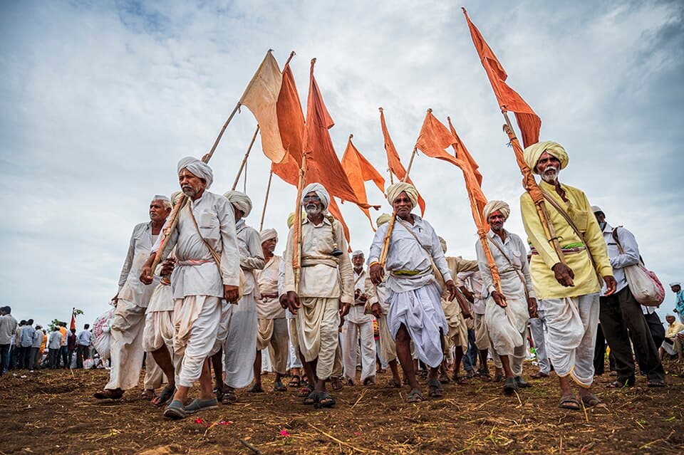 Varkaris on the wari: A dindi of varkaris with saffron flags, walking the wari to Pandharpur for Ashadhi Ekadashi.