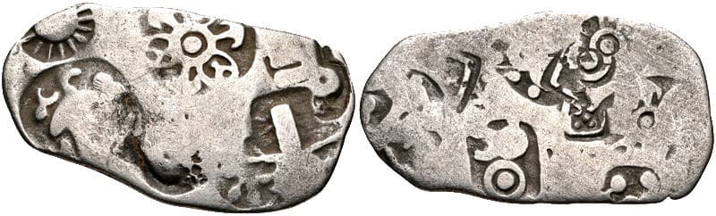 A punch marked coin of Magadha: Punch marked coins, early coins marked with symbols punched onto metal, show monetisation, trade and an exchange economy.